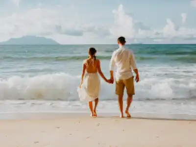 Couple cycling at Anse Source d'Argent beach, Seychelles honeymoon travel package